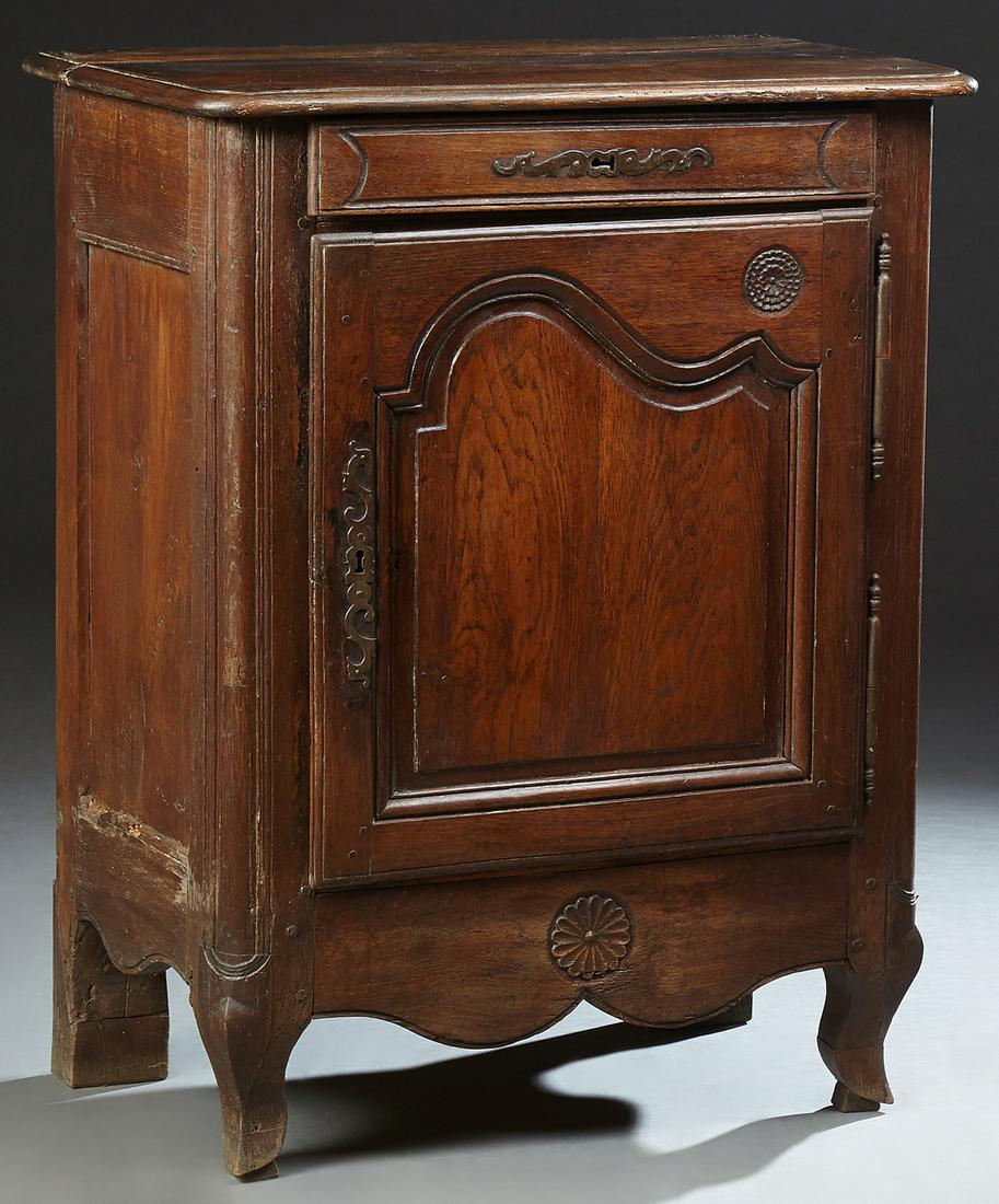 French Provincial Louis XV Style Carved Oak: French Provincial Louis XV Style Carved Oak Confiturier, c. 1800, the rounded corner top over a frieze drawer and an arched fielded panel cupboard with iron fiche hinges and escutcheons, on short squa