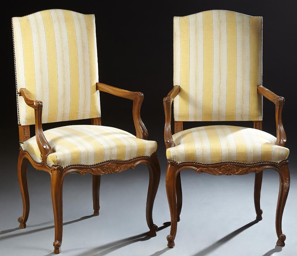 Pair of French Louis XV Style Carved Beech Fauteuils,: Pair of French Louis XV Style Carved Beech Fauteuils, 20th c., the canted arched upholstered backs over straight arms, to a bowed cushion seat, on cabriole legs, in gold striped fabric with iron tack 