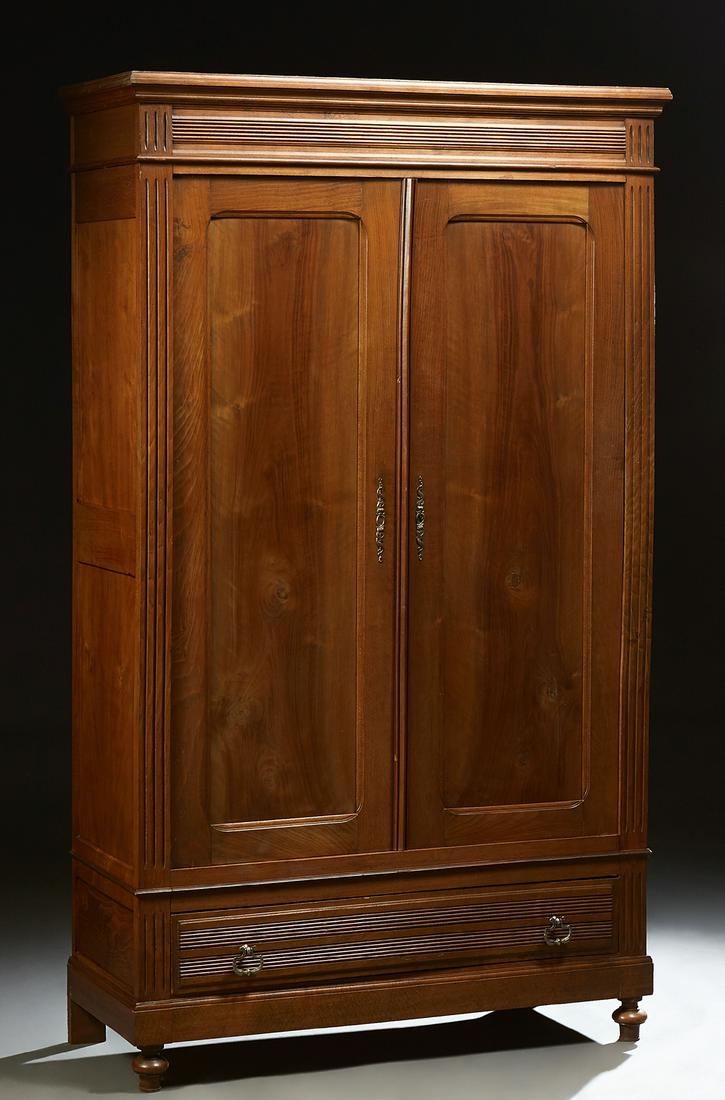 French Provincial Louis Philippe Carved Walnut and: French Provincial Louis Philippe Carved Walnut and Beech Armoire, 19th c., the stepped crown over double paneled doors over a reeded bottom drawer, flanked by reeded pilasters, on a plinth base, on tu