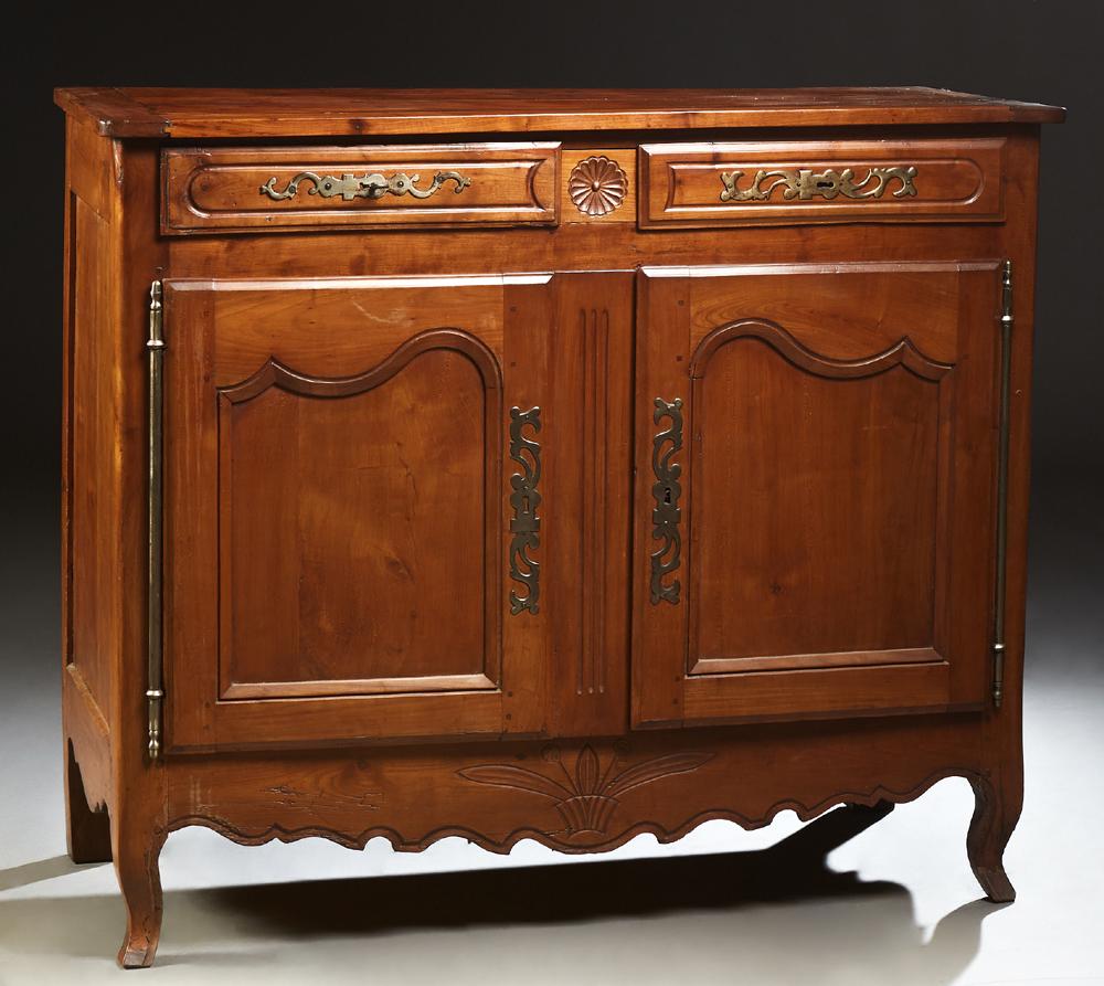 French Provincial Carved Cherry Louis XV Style: French Provincial Carved Cherry Louis XV Style Sideboard, 19th c., the rounded corner top over two frieze drawers, above double cupboard doors with long brass fiche hinges and escutcheons, flanking a 