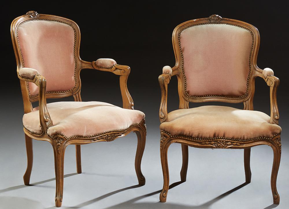 Pair of French Louis XV Style Upholstered Beech: Pair of French Louis XV Style Upholstered Beech Fauteuils, 20th c., the floral carved crest above an upholstered shield shaped back, and serpentine seat flanked by upholstered arms, on serpentine legs