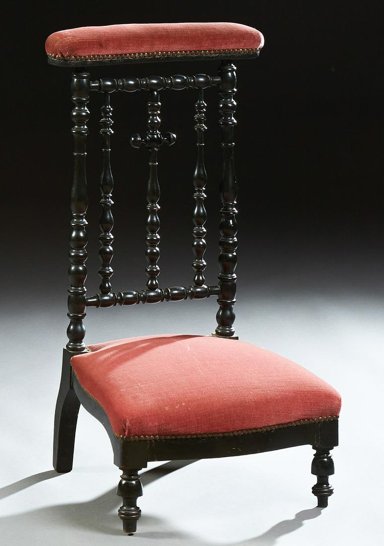 French Carved Ebonized Beech Prie Dieu, 19th c., the: French Carved Ebonized Beech Prie Dieu, 19th c., the curved armrest over a cruciform turned and tapered back splat, above a serpentine seat on turned legs, the armrest and seat in maroon velveteen uph