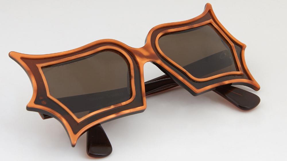 Pair of Limited Edition Safilo Sunglasses, inspired by: Pair of Limited Edition Safilo Sunglasses, inspired by Peggy Guggenheim, with butterfly shaped orange lucite frames, the right interior temple stamped "Peggy 001 by Safilo," the left interior temple s
