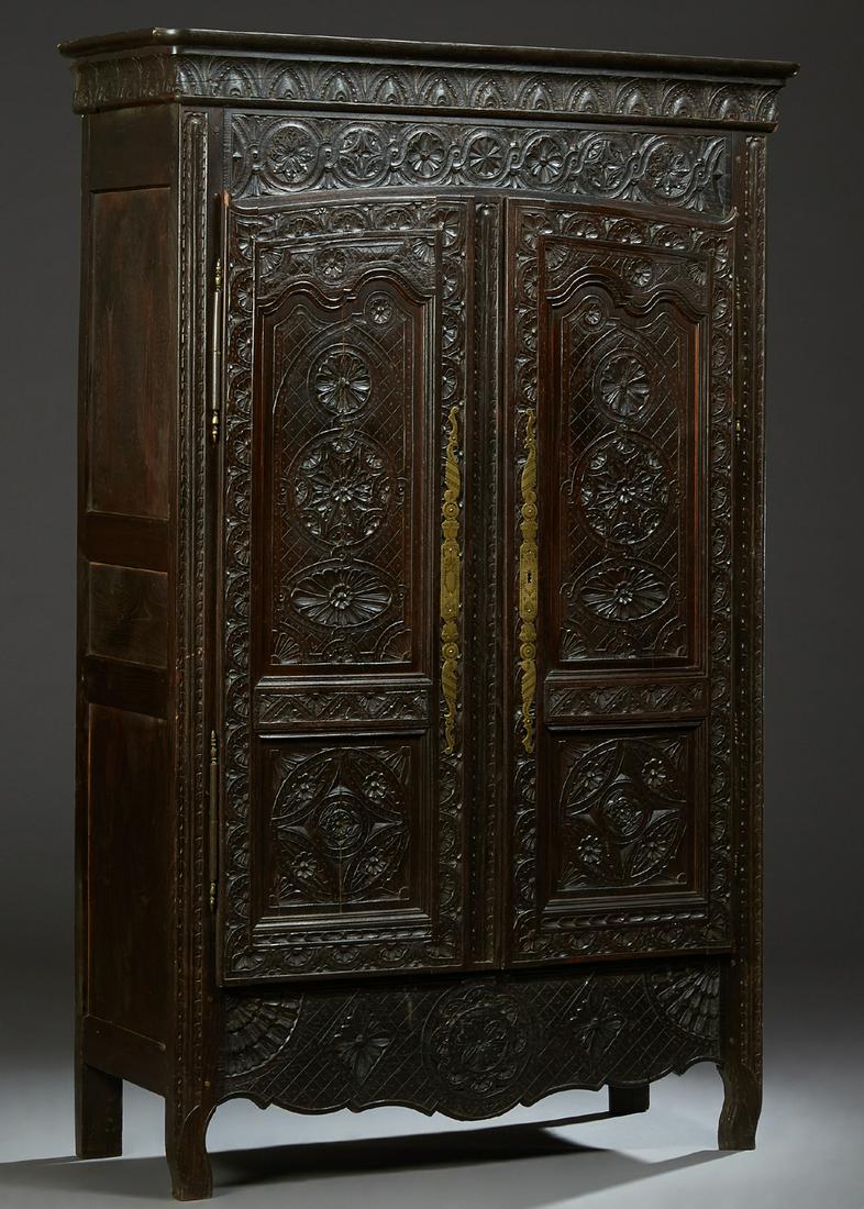 French Provincial Carved Oak Louis XV Style Armoire,: French Provincial Carved Oak Louis XV Style Armoire, 19th c., probably Brittany, the carved corner crown over arched three panel double doors with floral and rosette carving, with brass escutcheons an