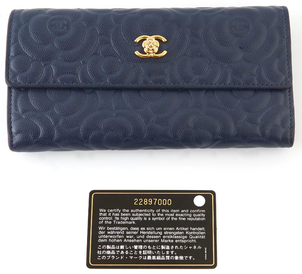 Chanel Navy Blue Camellia Embossed Leather Logo Flap: Chanel Navy Blue Camellia Embossed Leather Logo Flap Wallet, c.2016-2017, the calf leather with a golden brass Coco Chanel logo combined with a camellia, opening to two card holders, four bill compart