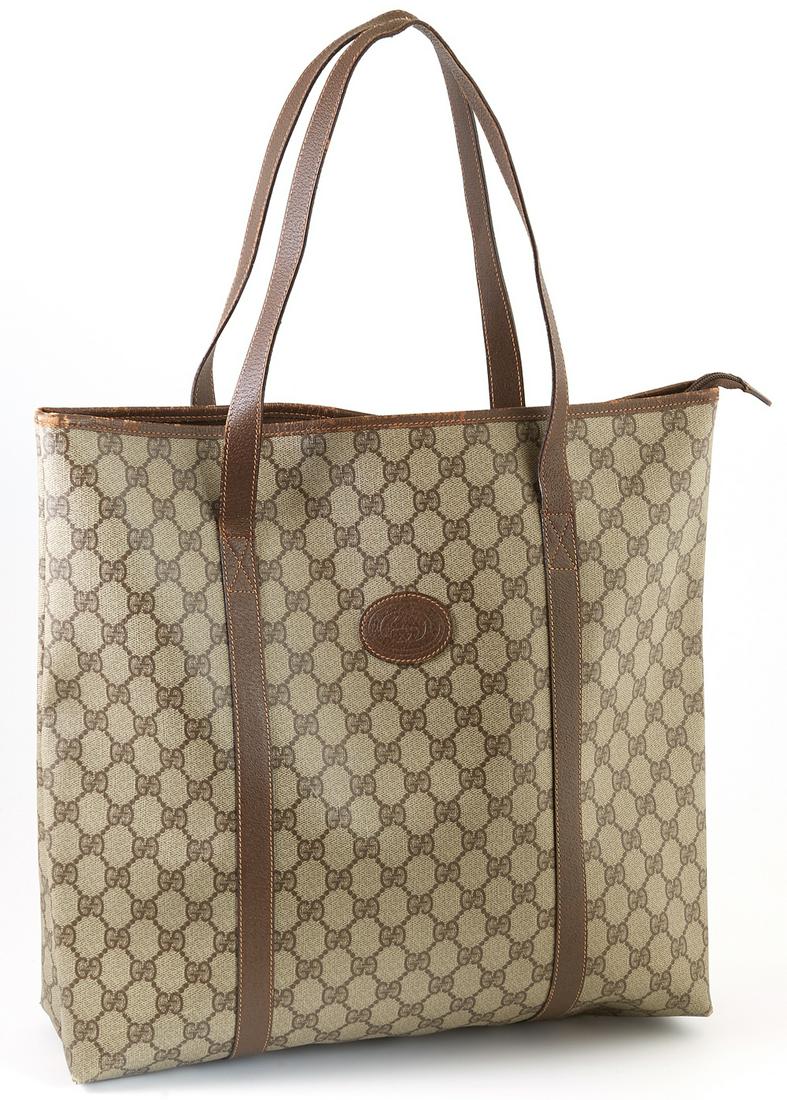Gucci Beige Supreme Coated Canvas Accessory Collection: Gucci Beige Supreme Coated Canvas Accessory Collection Large Tote Shoulder Bag, the exterior with dark brown leather straps, the top opening to a light brown canvas lined interior, H.- 14 1/2 in., W.-
