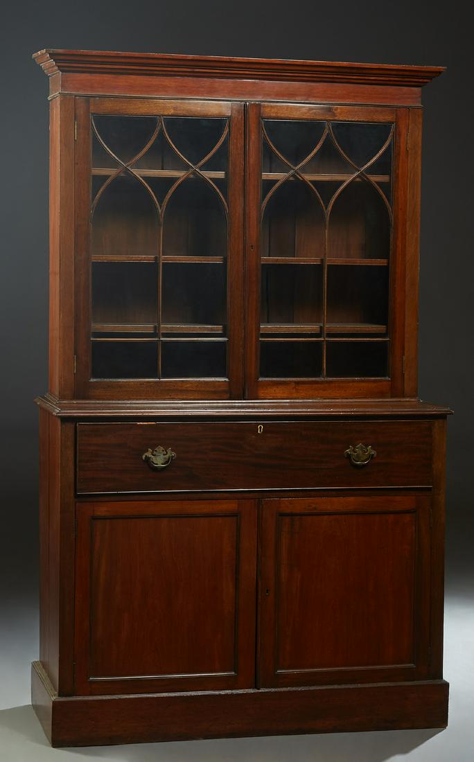 English Carved Mahogany Bookcase Cupboard, early 20th: English Carved Mahogany Bookcase Cupboard, early 20th c., the ogee crown over double Gothic glazed mullioned doors, on a base with a fall front secretary with an inset gilt tooled leather writing surf
