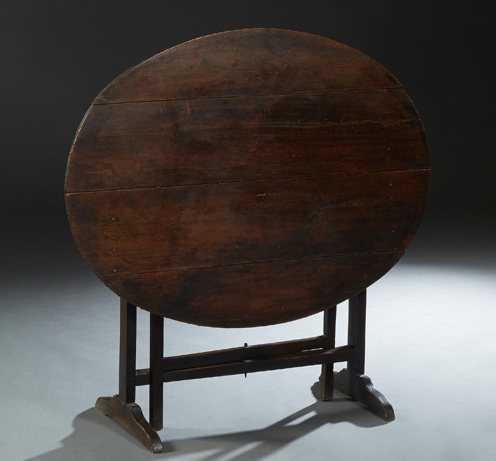 French Provincial Carved Pine Wine Tasting Table, 19th: French Provincial Carved Pine Wine Tasting Table, 19th c., the oval four board folding top on a folding trestle base, H.- Closed- 43 in., W.- 43 1/2 in., D.- 17 1/2 in., Open- H.- 28 1/4 in., w.- 43 1