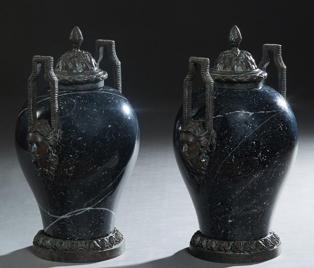 Pair of Bronze Mounted Empire Style Black Marble: Pair of Bronze Mounted Empire Style Black Marble Covered Baluster Urns, 20th/21st c., the sides with ring mask handles, on a relief decorated circular bronze base, H.- 14 3/4 in., W.- 11 in., D.- 8 in