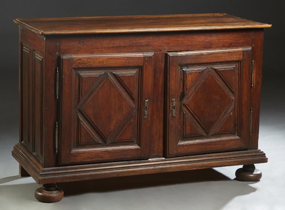 French Louis XIII Style Carved Walnut Sideboard, 19th: French Louis XIII Style Carved Walnut Sideboard, 19th c., the stepped rounded edge and corner top over double cupboard doors with applied geometric decoration and iron fiche hinges and escutcheons, on