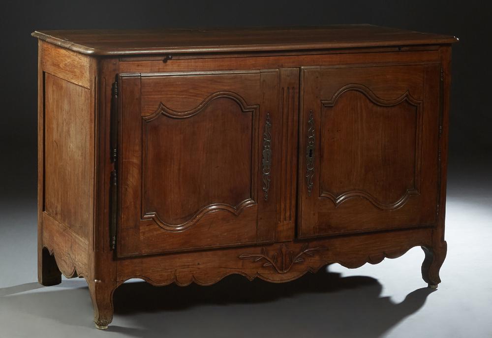 French Provincial Louis XV Style Carved Walnut: French Provincial Louis XV Style Carved Walnut Sideboard, 19th c., the stepped rounded corner three board top over double arched panel cupboard doors with iron fiche hinges and escutcheons, flanking a