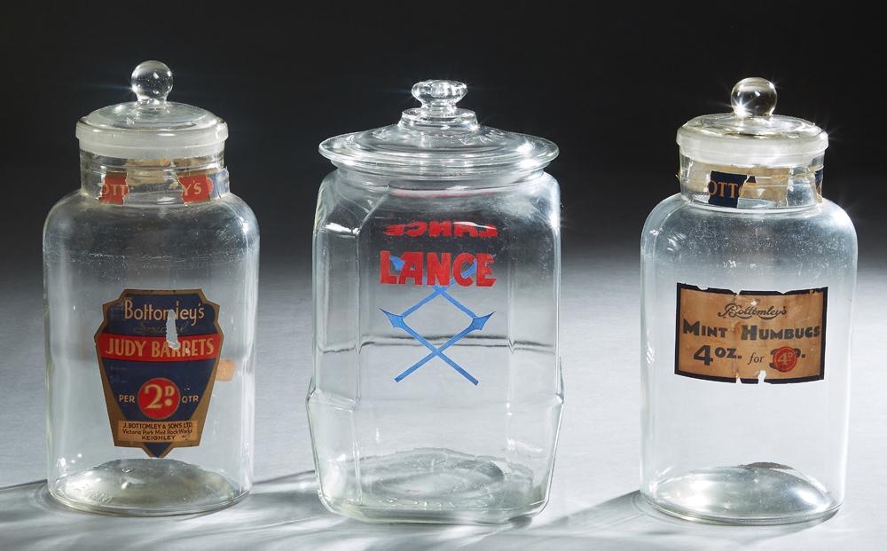 Three Glass Countertop Advertising Jars, 20th c., one: Three Glass Countertop Advertising Jars, 20th c., one for "Bottomley's Mint Humbugs"; one for Lance products; and one for "Bottomley's Judy Barrets," Humbugs- H.- 13 1/4 in., Dia.- 6 in. (3 Pcs.)