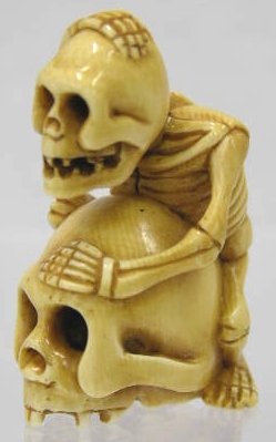 Carved Ivory Netsuke, 20th c., of a skeleton ridin: Carved Ivory Netsuke, 20th c., of a skeleton riding a skull, signed, H.- 1 3/4 in., W.- 1 in., D.- 1 1/8 in.