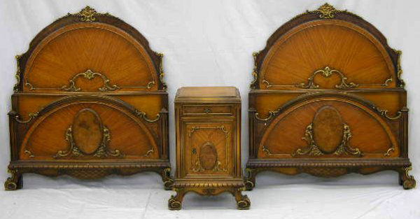 American Carved Mahogany Four Piece Bedroom Suite,: American Carved Mahogany Four Piece Bedroom Suite, c. 1940, consisting of a pair of single beds with arched headboards, a chest with a central band of drawers flanked by two narrow hanging cupboards,