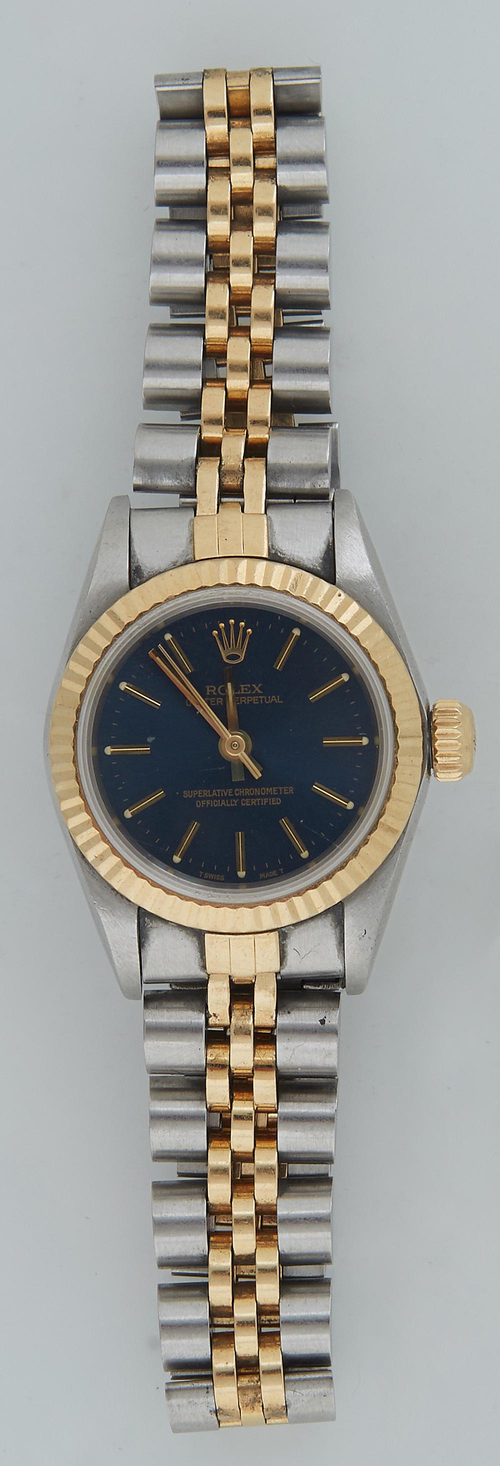 Lady's Stainless Steel and 18K Yellow Gold Rolex Oyster: Lady's Stainless Steel and 18K Yellow Gold Rolex Oyster Perpetual Wristwatch, self winding, with a black face, gold hands, chapter marks and bezel, with a stainless and 18K yellow gold link band. Prov