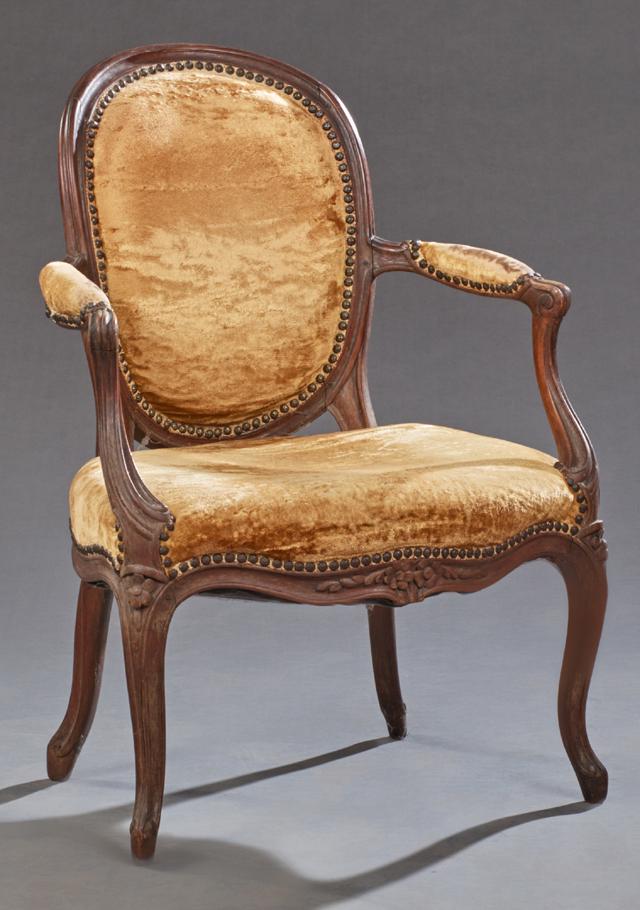 French Louis XV Style Carved Walnut Fauteuil, late 19th: French Louis XV Style Carved Walnut Fauteuil, late 19th c., the oval upholstered medallion back over a bowed upholstered seat, flanked by upholstered arms on reeded scrolled cabriole legs with toupie 