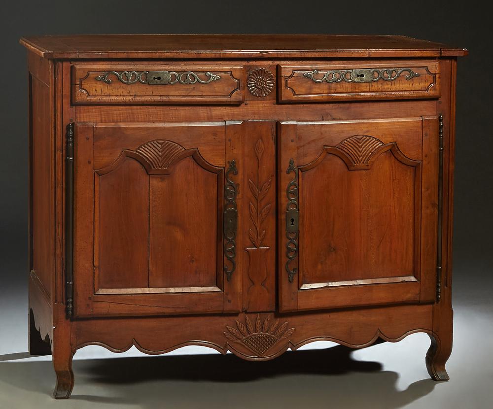 French Provincial Louis XV Style Carved Cherry: French Provincial Louis XV Style Carved Cherry Sideboard, 19th c., the ogee edge canted corner over two frieze drawers with iron escutcheons, over fielded panel cupboard doors with iron fiche hinges a