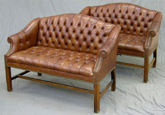 Pair of Chippendale Style Camelback Settees, 20th: Pair of Chippendale Style Camelback Settees, 20th c., with tufted brown vinyl backs and seats and brass tack upholstery, on reeded square legs joined by stretchers, H.- 34 in., W.- 50 in., D.- 28 in.