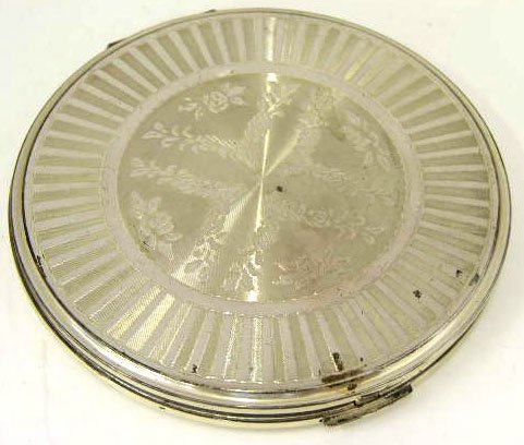 Lady's Sterling Volupte Compact, mid 20th c., the: Lady's Sterling Volupte Compact, mid 20th c., the lid with engraved and floral decoration, the interior of the lid mounted with a mirror, H.- 3/8 in., Dia.- 4 1/8 in.