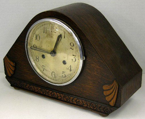 English Carved Oak Art Deco Mantel Clock, c. 1940,: English Carved Oak Art Deco Mantel Clock, c. 1940, of arched form, time and strike, lacking the pendulum, H.- 8 1/2 in., W.- 13 1/4 in., D.- 4 3/4 in.