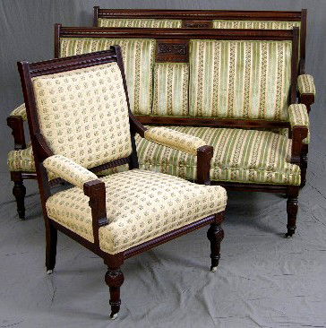 American Carved Walnut Parlor Suite, c. 1880, cons: American Carved Walnut Parlor Suite, c. 1880, consisting of a pair of settees and an armchair, the settees with carved central panels of flowers and leaves, the settes upholstered identically, the arm