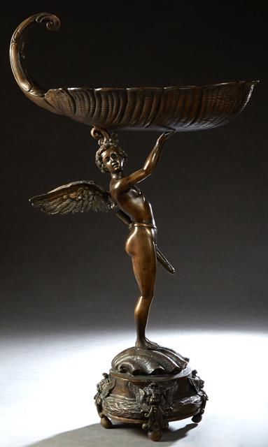 Patinated Bronze Garden Figure, 20th c., of a nude: Patinated Bronze Garden Figure, 20th c., of a nude putto warrior upholding a large shell, perhaps a bird bath, on a relief shell circular base on four winged lions' head feet, H.- 42 1/2 in., W.- 24 i