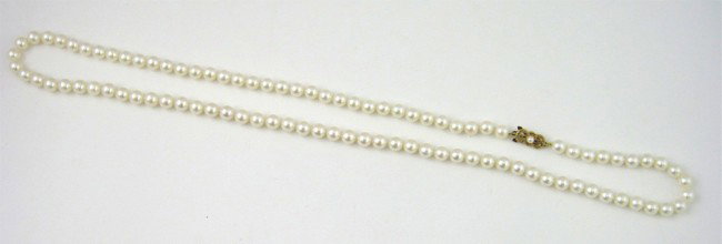 Strand of Mikimoto 7.5mm Cultured Pearls, with an : Strand of Mikimoto 7.5mm Cultured Pearls, with an 18K yellow gold clasp with a central 3.5mm cultured pearl, L.- 30 in.