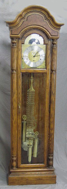 Howard Miller Oak Grandfather Clock, Ser. # 35733,: Howard Miller Oak Grandfather Clock, Ser. # 35733, with a bonnet top over a brass face, with beveled glass door and sides, with a Westminster, Whittington, and Winchester Chime, as found, H.- 83 1/2 i