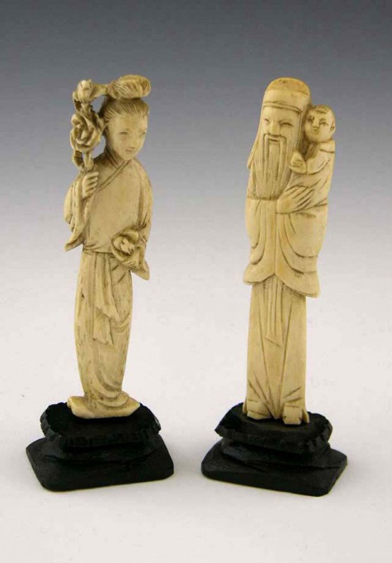 Pair of Carved Ivory Figures, early 20th c., of a : Pair of Carved Ivory Figures, early 20th c., of a woman, and a man with a child, on carved ebonized wood stands, Figure- H.- 4 in., Total H.- 4 5/8 in., W.- 1 1/2 in., D.- 1 1/16 in.