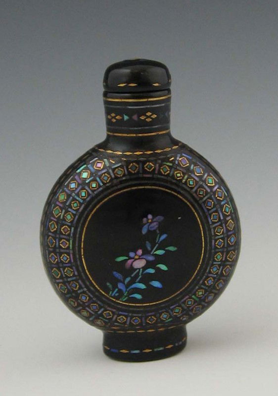 Lac Burgaute Snuff Bottle, late 19th c., inlaid wi: Lac Burgaute Snuff Bottle, late 19th c., inlaid with abalone and gold foil, the sides with reserves of flowering plants, H.- 2 1/8 in., W.- 1 1/2 in., D.- 5/8 in. Provenance: Collection of Virginia A.