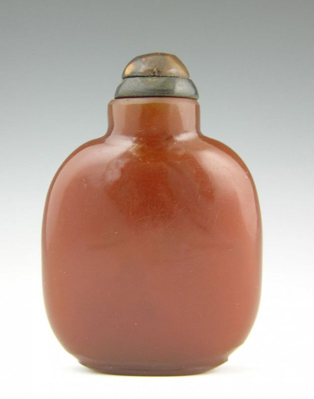 Carved Red Agate Snuff Bottle, early 20th c., with: Carved Red Agate Snuff Bottle, early 20th c., with a Carved hard stone stopper, H.- 2 1/2 in., W.- 1 7/8 in., D.- 7/8 in. Provenance: Collection of Virginia A. Rice, New Orleans Louisiana; member of t