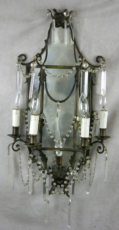 Unusual Brass Four Light Wall Sconce, 19th c., wi: Unusual Brass Four Light Wall Sconce, 19th c., with a mirror back, hung with prisms and prism chains, with a central prism spire, now electrified, H.- 30 in., W.- 14 1/2 in., D.- 7 in.