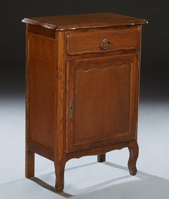 Diminutive Louis XV Style Carved Oak Confiturier, 20th c., the bowed stepped edge rounded corner top: Diminutive Louis XV Style Carved Oak Confiturier, 20th c., the bowed stepped edge rounded corner top over a frieze drawer and a fielded panel cupboard door with iron fiche hinges and escutcheon, on ca