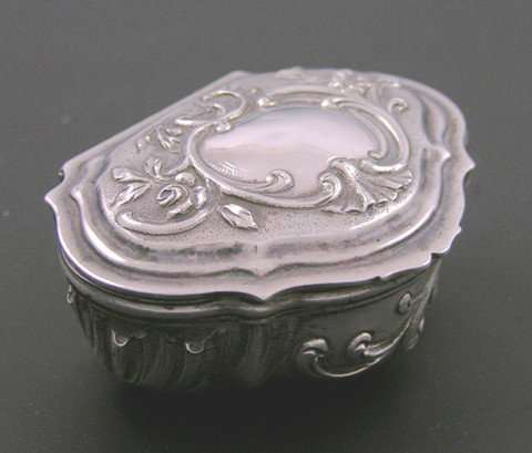 French First Standard Silver Pill Box, c. 1850, Pa: French First Standard Silver Pill Box, c. 1850, Paris, of lobed demilune form, the sides and lid with relief decoration, the bottom stamped "FE, SU, and FTL," H.- 1 in., W.- 2 3/16 in., D.- 1 11/16 in