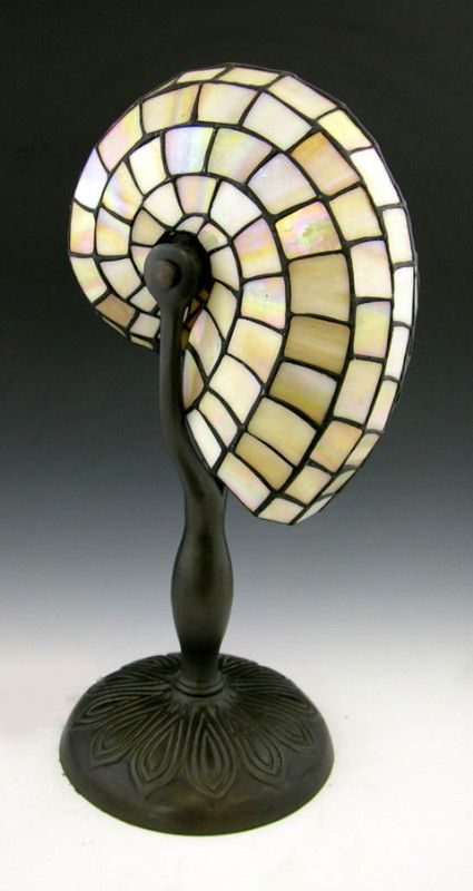 Contemporary Tiffany Style Nautilus Shell Desk lam: Contemporary Tiffany Style Nautilus Shell Desk lamp, the leaded slag glass shade on a bronze patinated base with relief base with floral decoration, H.- 18 in., Dia.- 7 1/2 in.