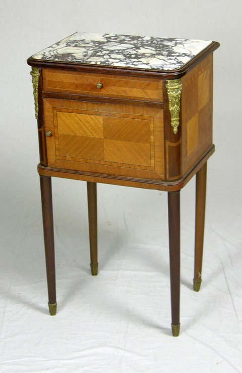 Inlaid Carved Mahogany Ormolu Mounted Night Stand: Inlaid Carved Mahogany Ormolu Mounted Night Stand, early 20th c., with a highly figured black and white inset marble top over a frieze drawer and a lower marble lined pot cupboard, the whole on tapere