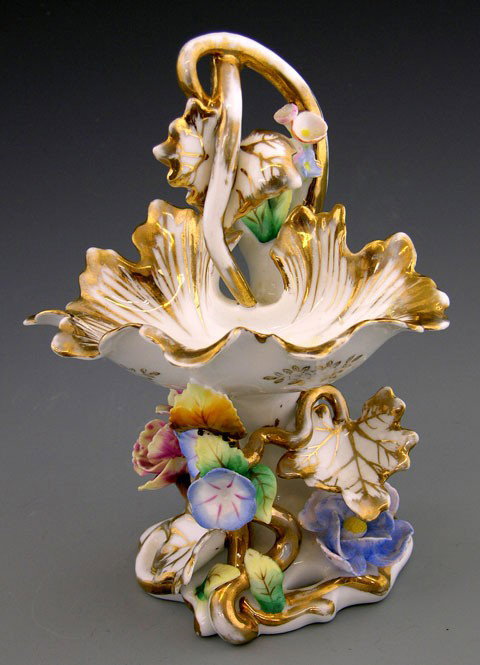 Old Paris Porcelain Sweetmeats Dish, 19th c., of s: Old Paris Porcelain Sweetmeats Dish, 19th c., of shell form, with a handle of entwined tendrils, on a relief floral decorated support with gilt highlights, H.- 7 1/4 in., W.- 5 1/2 in., D.- 3 7/8 in.