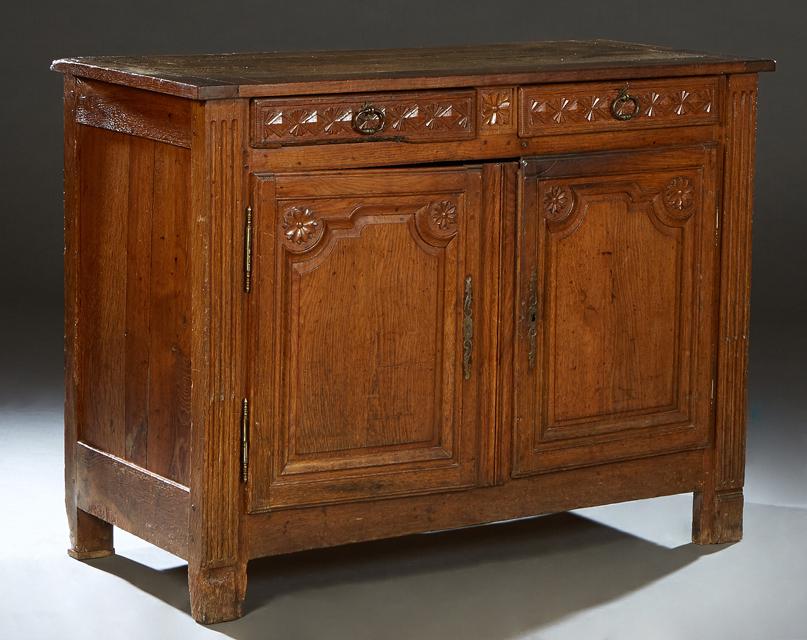 French Provincial Carved Oak Louis XVI Style Sideboard, 19th c., the four board top over two setback: French Provincial Carved Oak Louis XVI Style Sideboard, 19th c., the four board top over two setback frieze drawers, above two fielded panel cupboard doors with iron fiche hinges and escutcheons, flan
