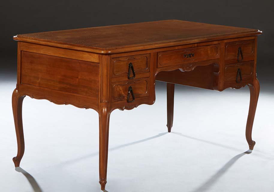 French Louis XV Style Carved Cherry Desk, early 20th c., the sloping edge rounded corner top over a (1 of 1)