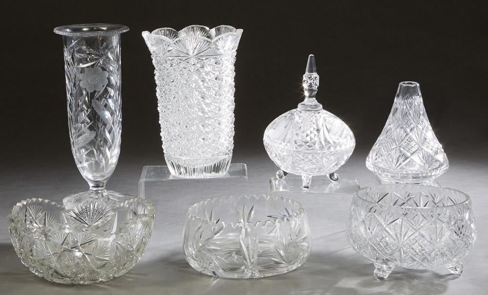 Seven Pieces of Cut Glass, 20th c., consisting of a tapered scalloped cylindrical example; a footed: Seven Pieces of Cut Glass, 20th c., consisting of a tapered scalloped cylindrical example; a footed example, a covered box; a tapered short vase, two saw tooth edge circular bowls; and one footed bowl