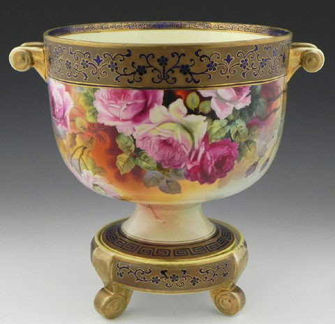 Large Noritake Porcelain Handled Urn, 20th c., th: Large Noritake Porcelain Handled Urn, 20th c., the side with hand painted floral decoration, with Greek key decoration on the border and the foot, on a conforming base on three scrolled feet, H.- 12 3