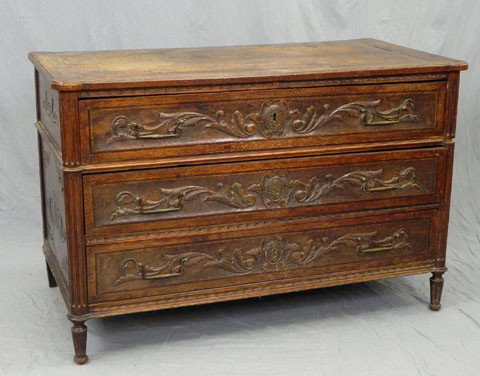 Louis XVI Style French Provincial Carved Oak Commo: Louis XVI Style French Provincial Carved Oak Commode, c. 1800, the cookie corner top over three leaf and scroll carved inlaid drawers, flanked by reeded rounded corner columns, the whole on tapered re