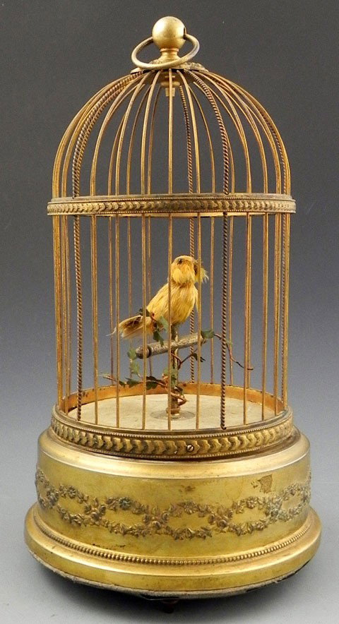 French Automation of a Feathered Canary, early 20t: French Automation of a Feathered Canary, early 20th c., the gilt brass cage decorated with embossed floral garlands covering the mechanical mechanism with the canary perched with branches inside, impr