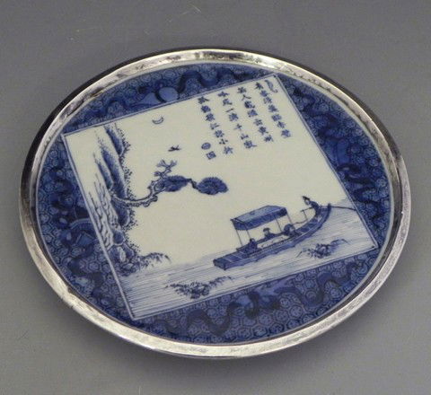 Chinese Circular Porcelain Trivet, early 19th c.,: Chinese Circular Porcelain Trivet, early 19th c., with blue decoration of a boat on a river, with a silver rim, signed on the bottom, H.- 5/8 in., Dia.- 6 1/2 in.