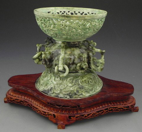 Chinese Carved Jade Tazza, early 20th century, the: Chinese Carved Jade Tazza, early 20th century, the circular bowl with a foliate pierced rim, raised on a bulbous support with eight applied ring handles to a molded dragon and scroll carved base, now 