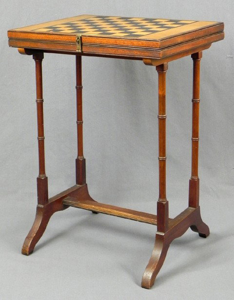 Diminutive Inlaid Carved Walnut Games Table, c. 19: Diminutive Inlaid Carved Walnut Games Table, c. 1910, the top with an inlaid chess board, swiveling to open to a polychromed inlaid backgammon board, the whole on turned trestle supports joined by a r