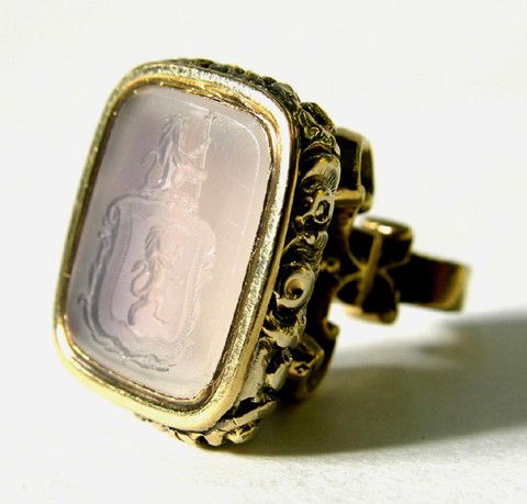 English Gold Plated Watch Fob Seal, 19th c., the a: English Gold Plated Watch Fob Seal, 19th c., the armorial carved moonstone with a shield with a lion rampant within and a lion with a scepter atop, on a relief decorated frame, H.- 3/4 in., W.- 5/8 in