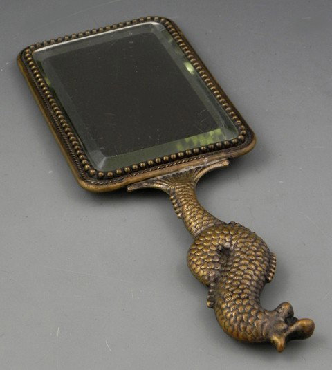 Unusual Japonesque Brass Hand Mirror, c. 1880, ver: Unusual Japonesque Brass Hand Mirror, c. 1880, verso with relief fan decoration, with a beveled glass, the handle in the form of a fish, H.- 9 3/4 in., W.- 3 5/8 in., D.- 5/8 in.
