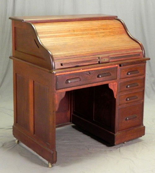 Oak and Mahogany Roll Top Desk, c. 1920, the S-rol: Oak and Mahogany Roll Top Desk, c. 1920, the S-roll tambour with cubby holes within, on a base with a left frieze drawer beside a single right pedestal with a writing slide over four graduated drawers