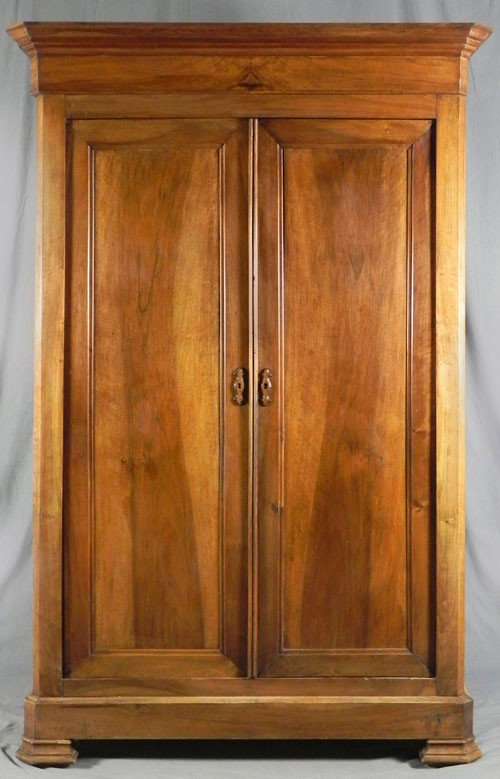 Louis Philippe Carved Walnut Armoire, c. 1850, the: Louis Philippe Carved Walnut Armoire, c. 1850, the shaped curved corner stepped crown over double paneled doors with wooden escutcheons, to a plinth base on large stepped shaped block feet, H.- 83 in.